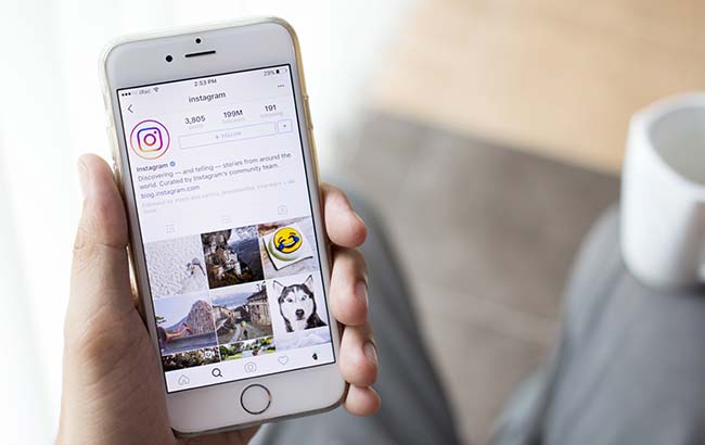 Person browsing Instagram profile grid on smartphone — representing Instagram audience engagement