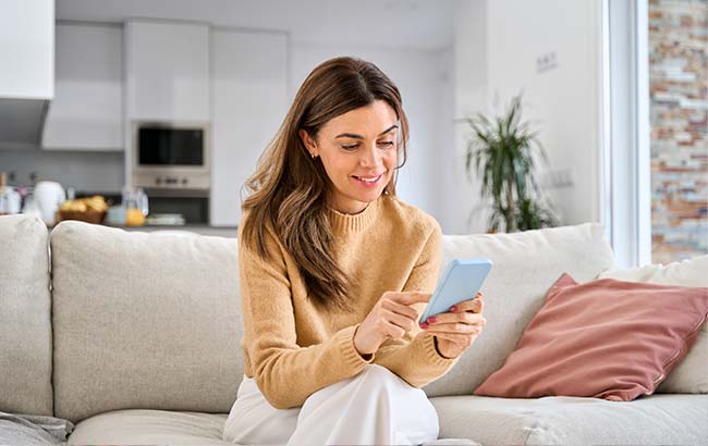 Woman engaging with a Google Ads campaign on her smartphone in a relaxed home setting