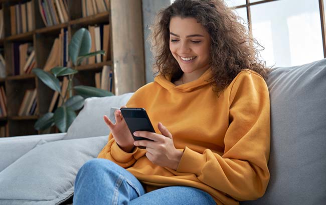 Young woman interacting with Instagram ads content in a cozy setting